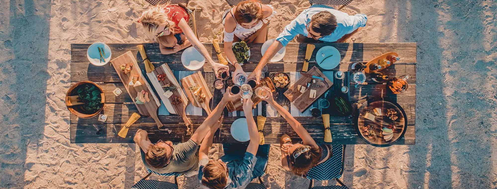 Group gathered around a picnic table sharing a meal using Picnic Time products